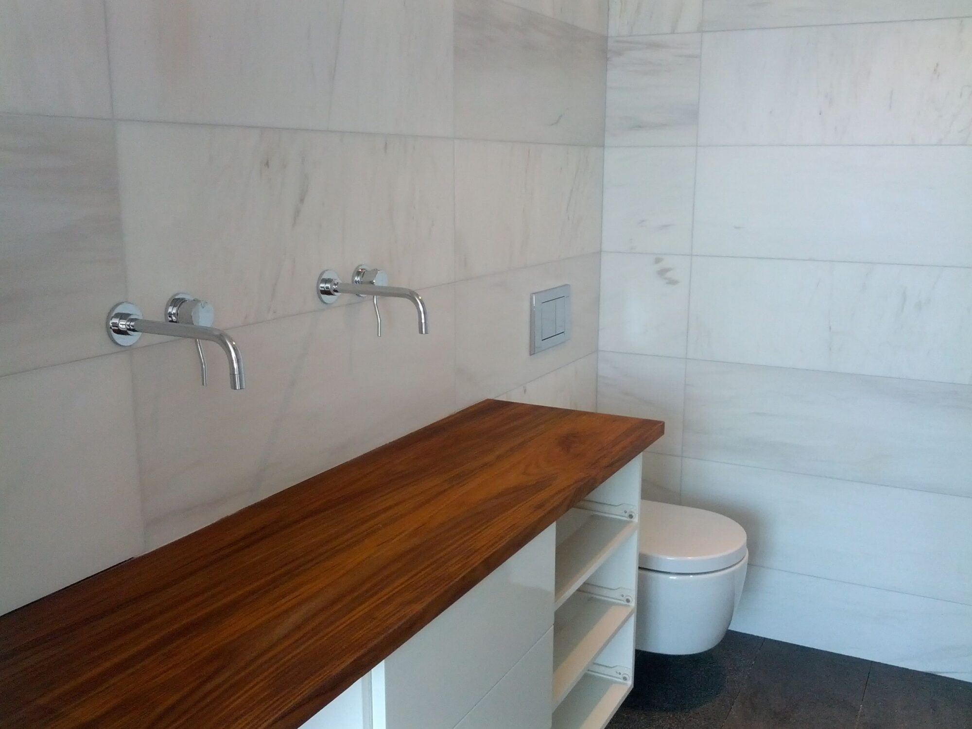 teak, teak counter, wall mount facets, two facets, wall mounted toilet, white toilet, large tiles