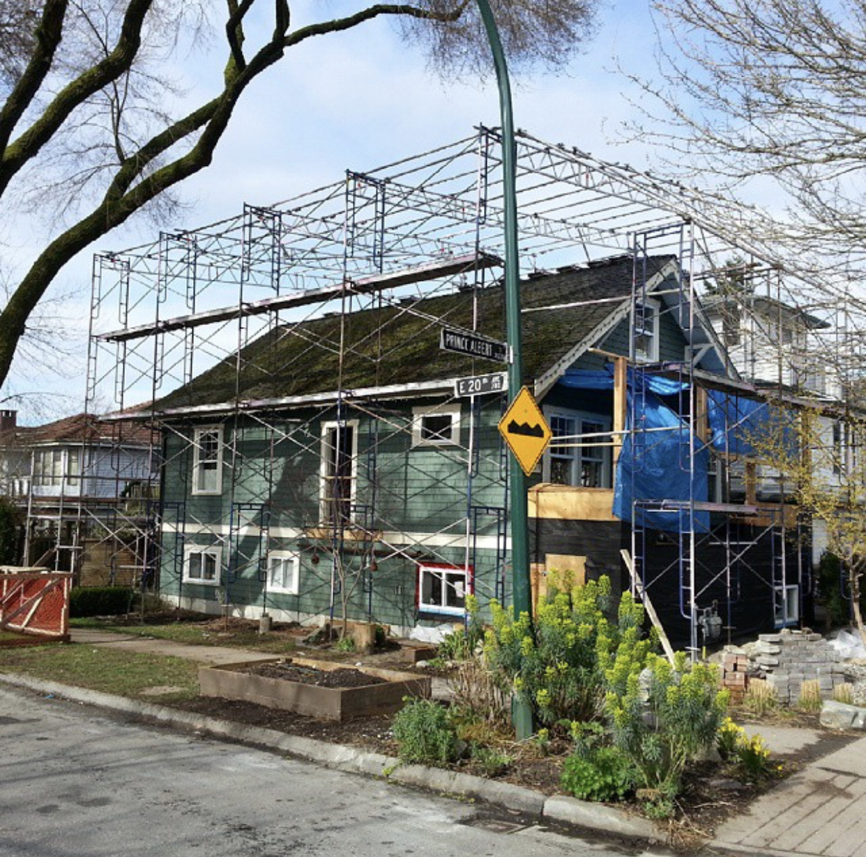 green traditional house, scaffolding, preparing for renovation, street view, construction