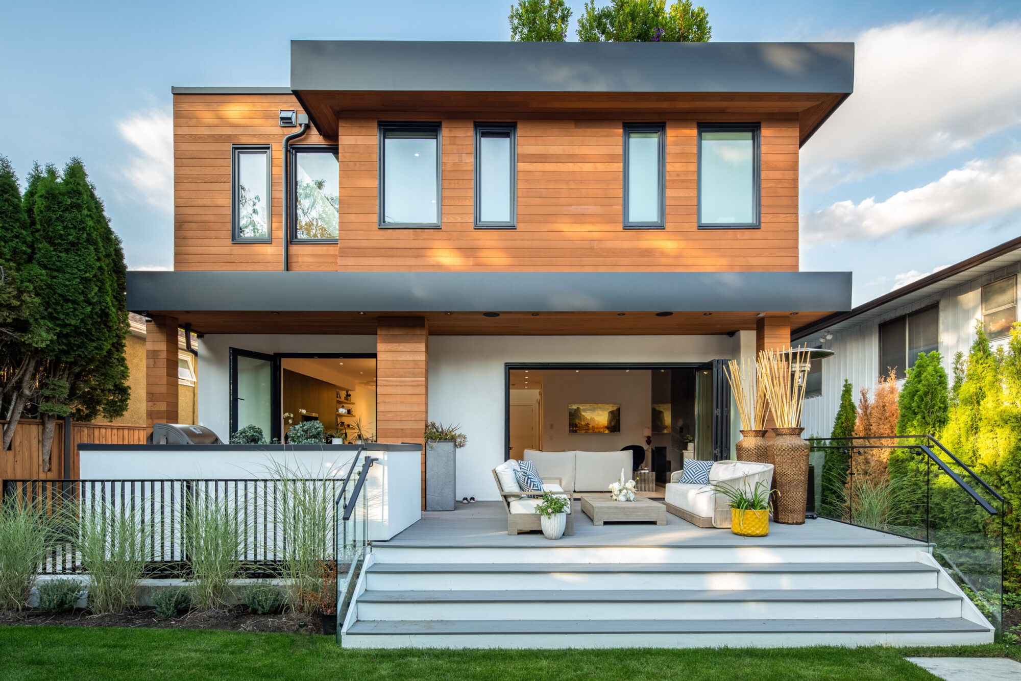 Exterior rear image of modern home looking into living room through folding door system