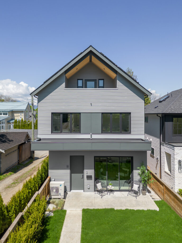 Front exterior image of grey gable roof Net Zero front back duplex